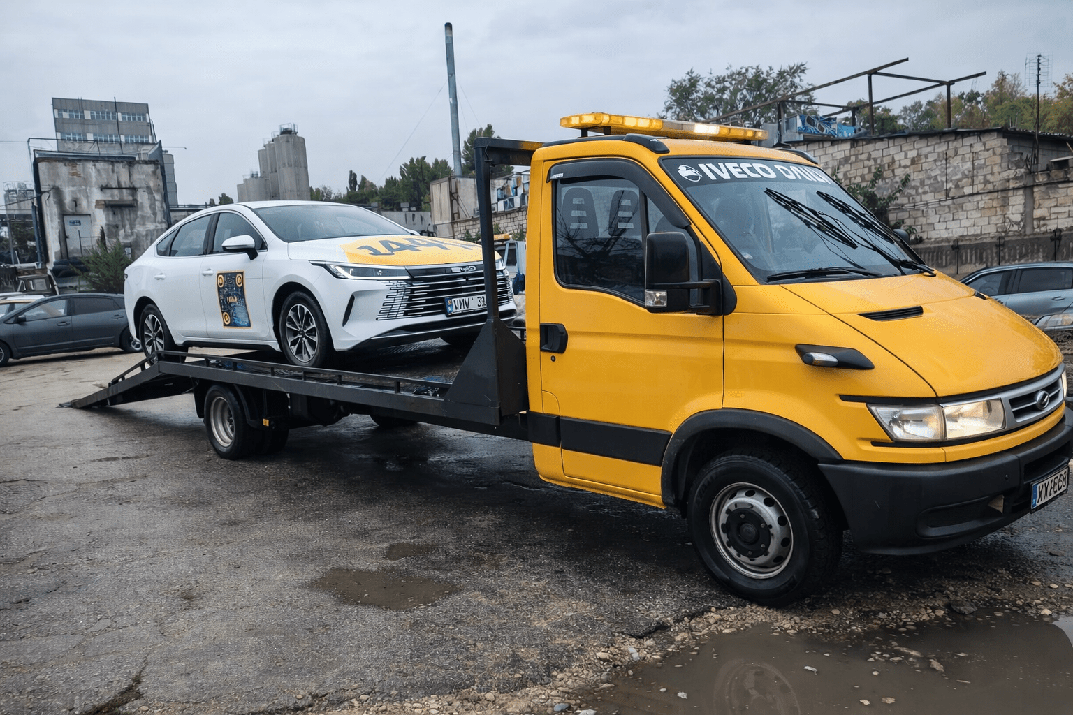 Evacuator auto transportând autoturism pe platformă în Chișinău, intervenție non-stop